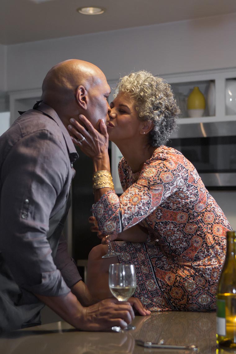 Older couple kissing over a bottle of wine I OneAZ | John Fedele Lifestyle Photography