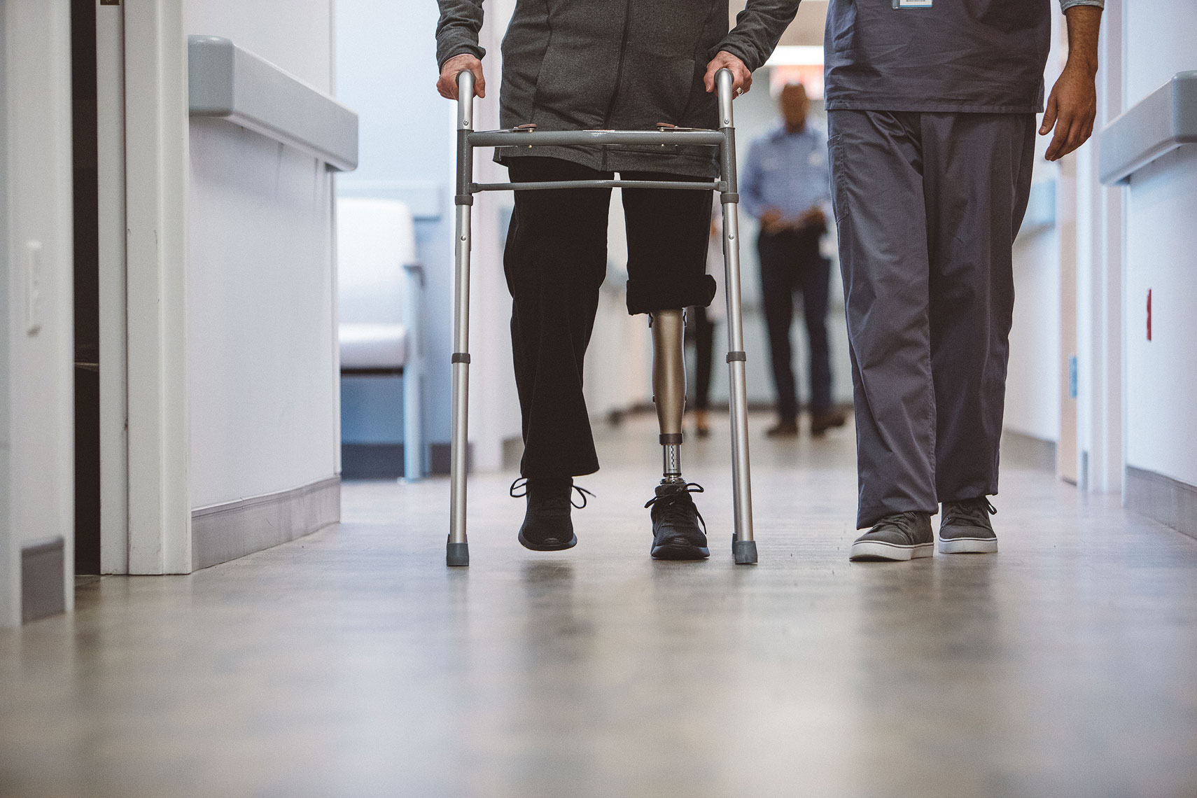 Patient with a prosthetic leg walking with a walker and a nurse |  Centene | John Fedele Lifestyle Photography