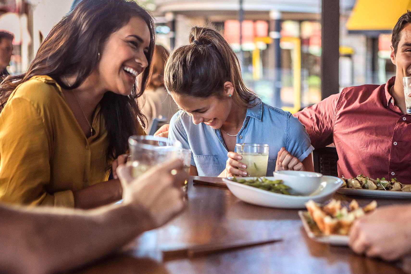 Women laughing with friends while eating Chinese food | P. F. Chang