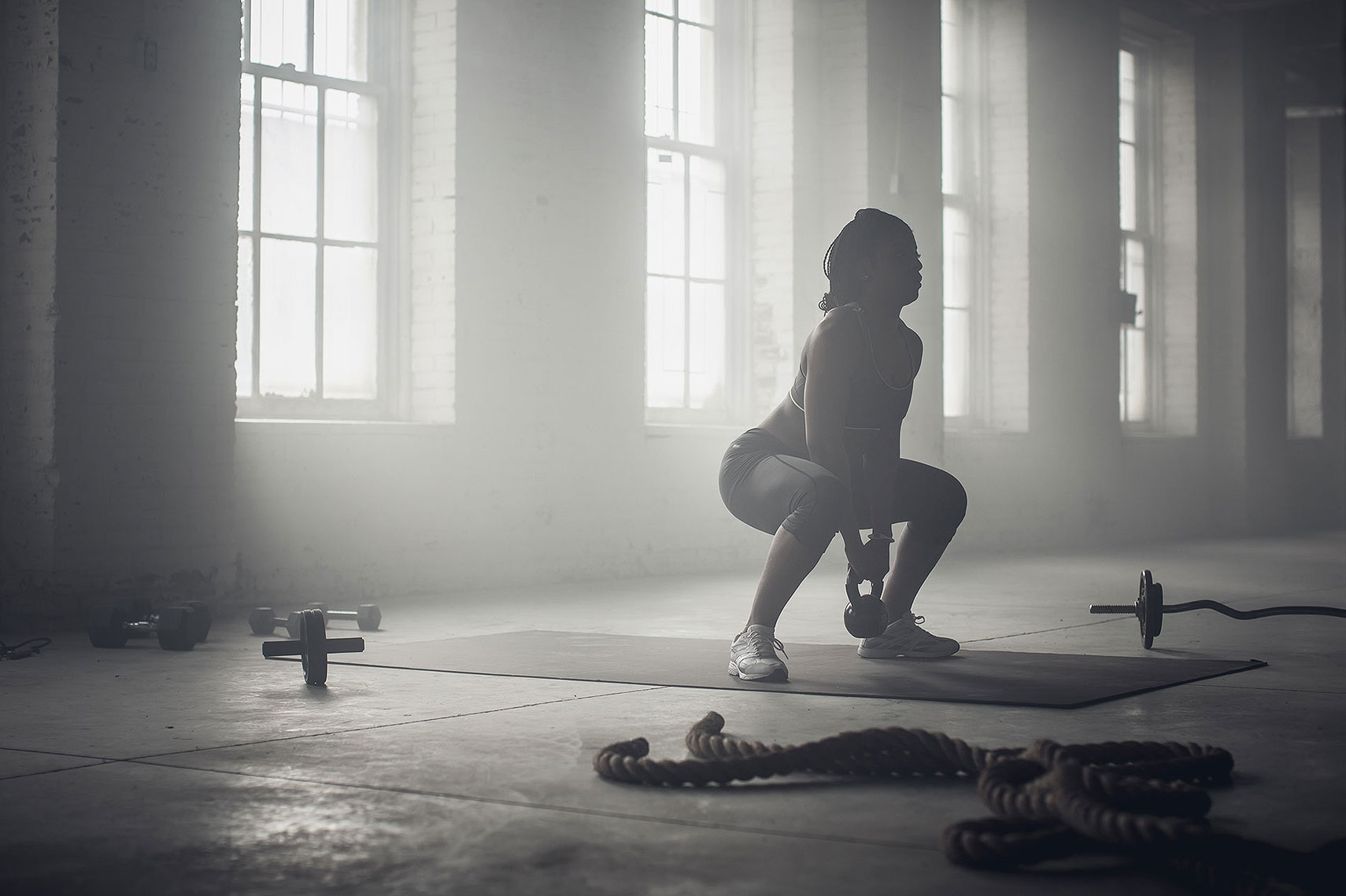 Women working out in an industrial gym with a kettle bell. | John Fedele Lifestyle Photography