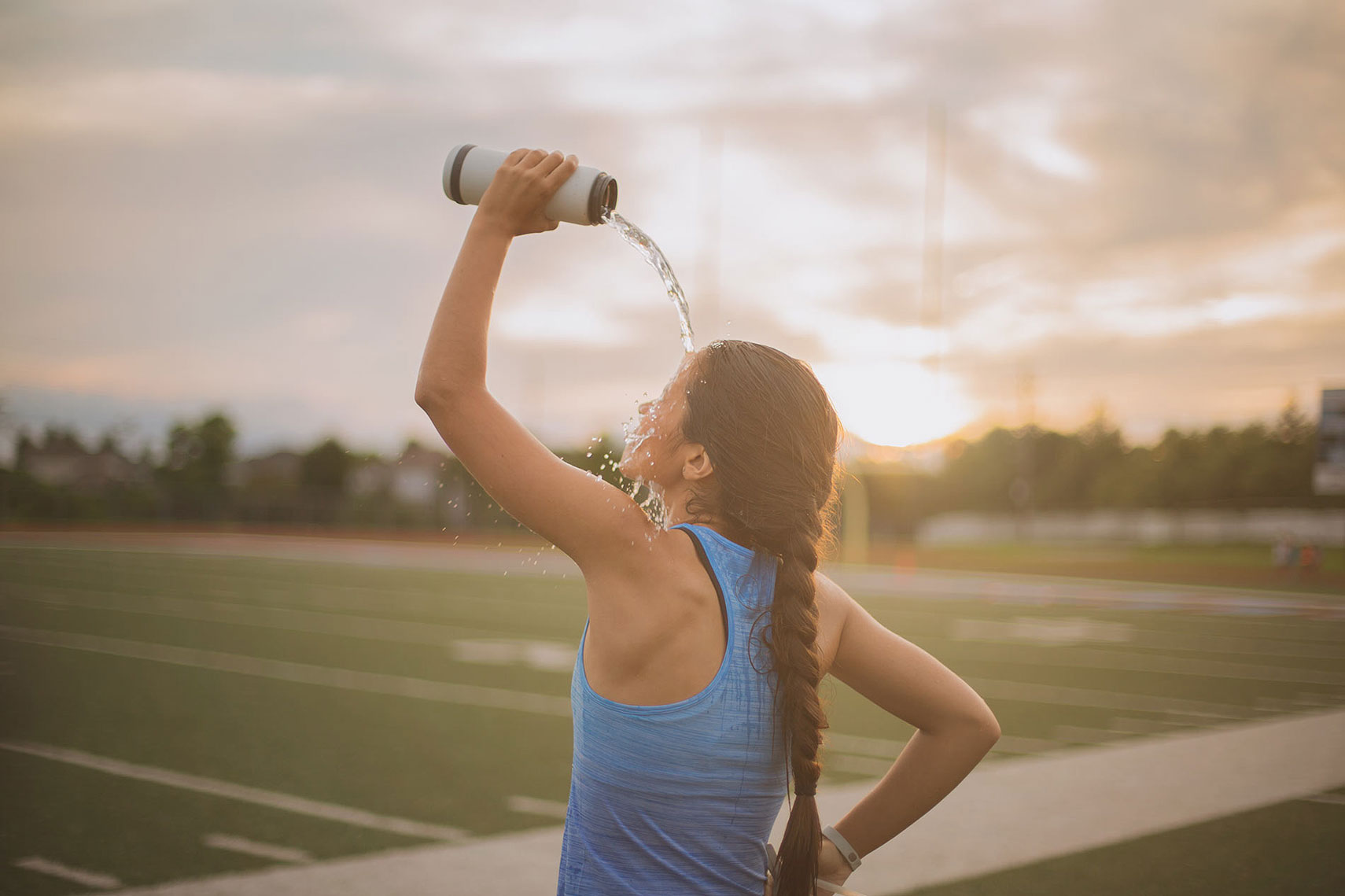Woman pouring water over her head to cool off. | John Fedele Lifestyle Photography