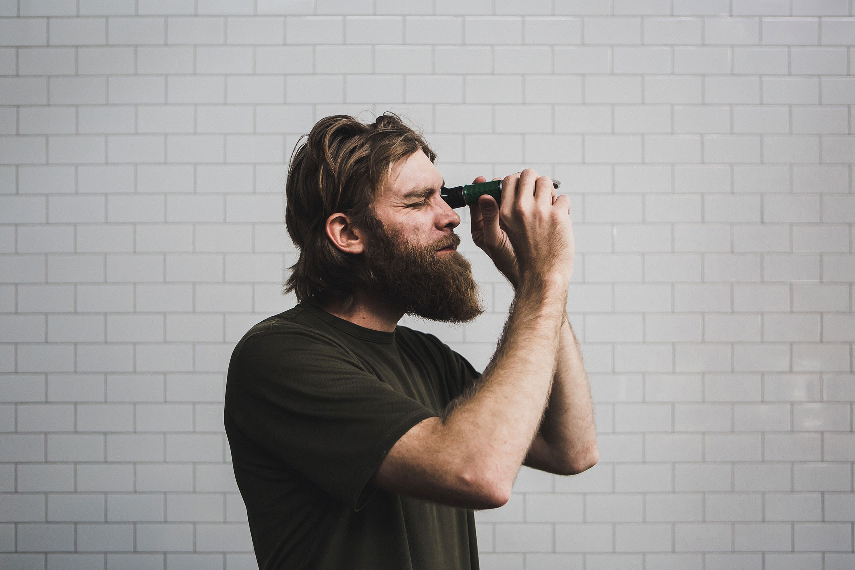 Man using a tool to inspect grains for the brewing process | Side Project Brewery | John Fedele Photography 