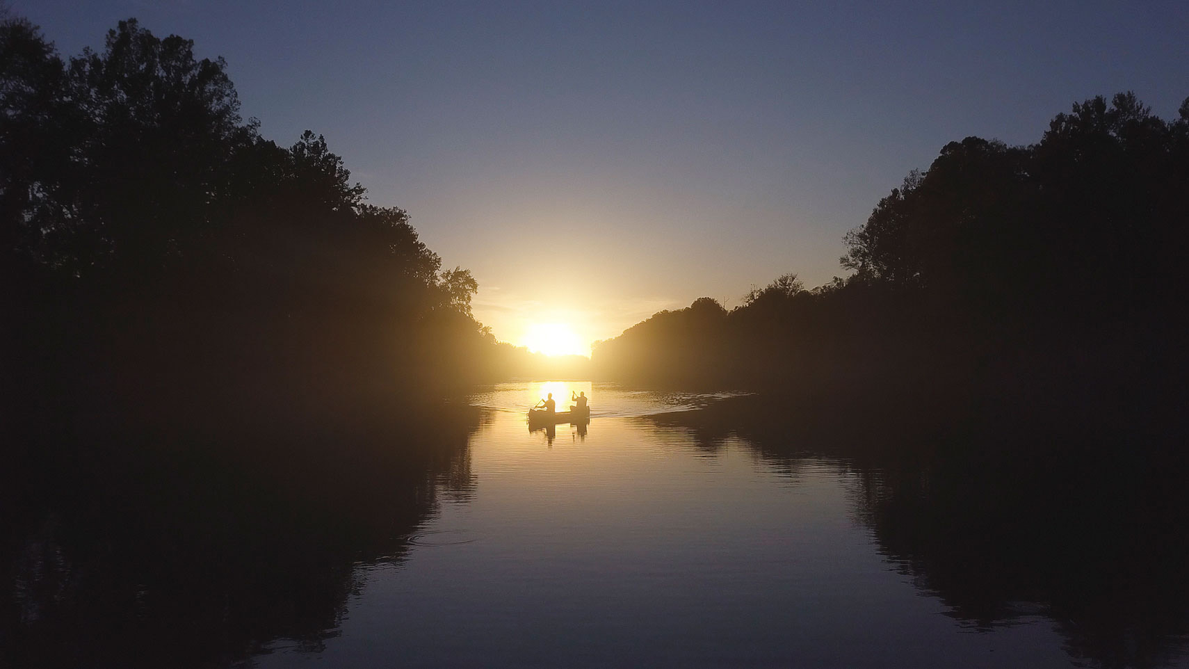 Two people floating in a canoe at sunset. | John Fedele Lifestyle Photography